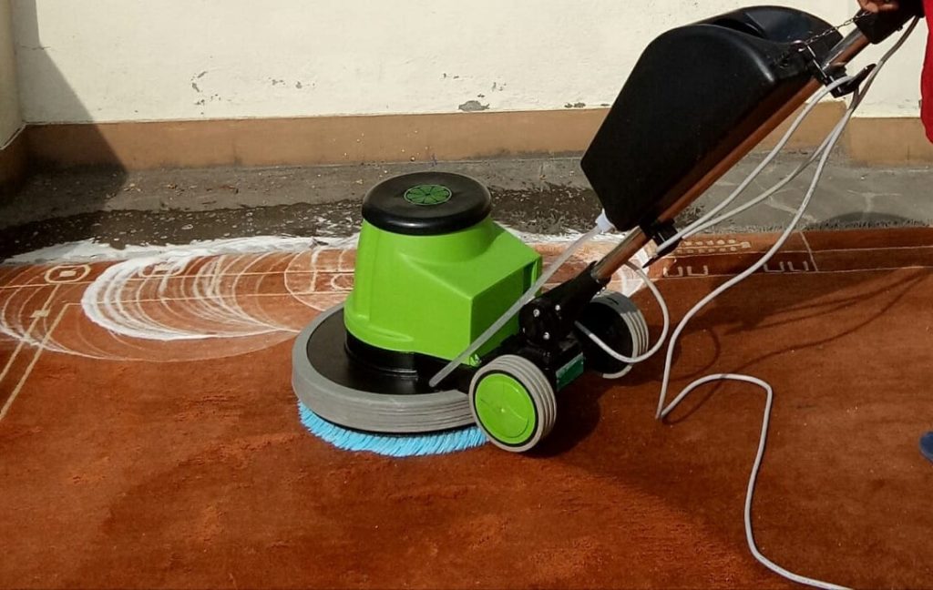 scrubbing carpet with green scrubbing machine