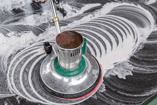 Cleaning black marble with scrubbing machine