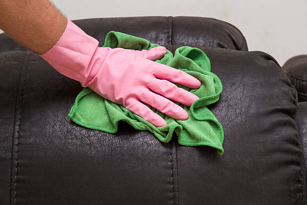 wiping natural black leather sofa with soft clothes